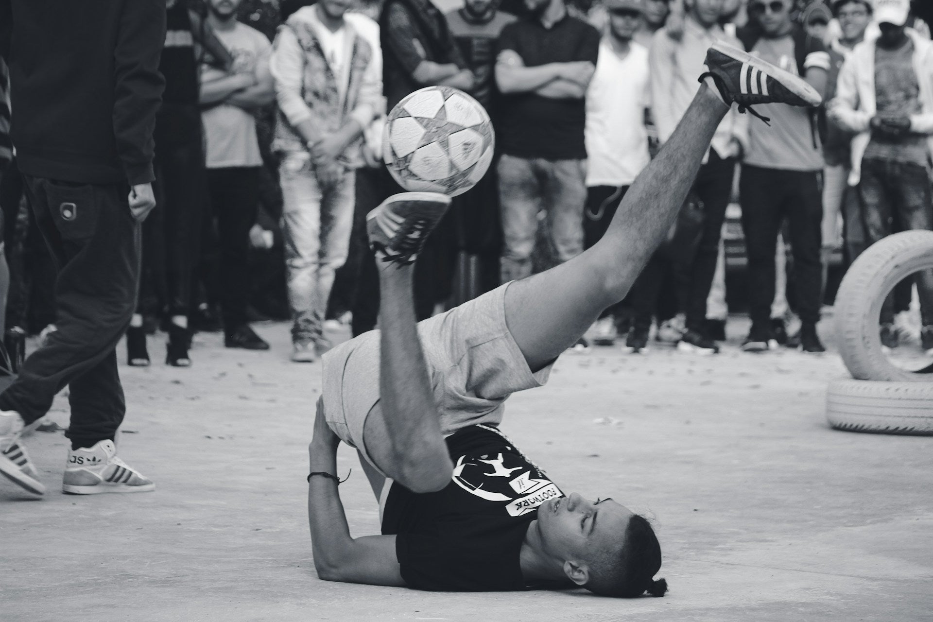 man in a sexual position balancing a soccer ball on his foot