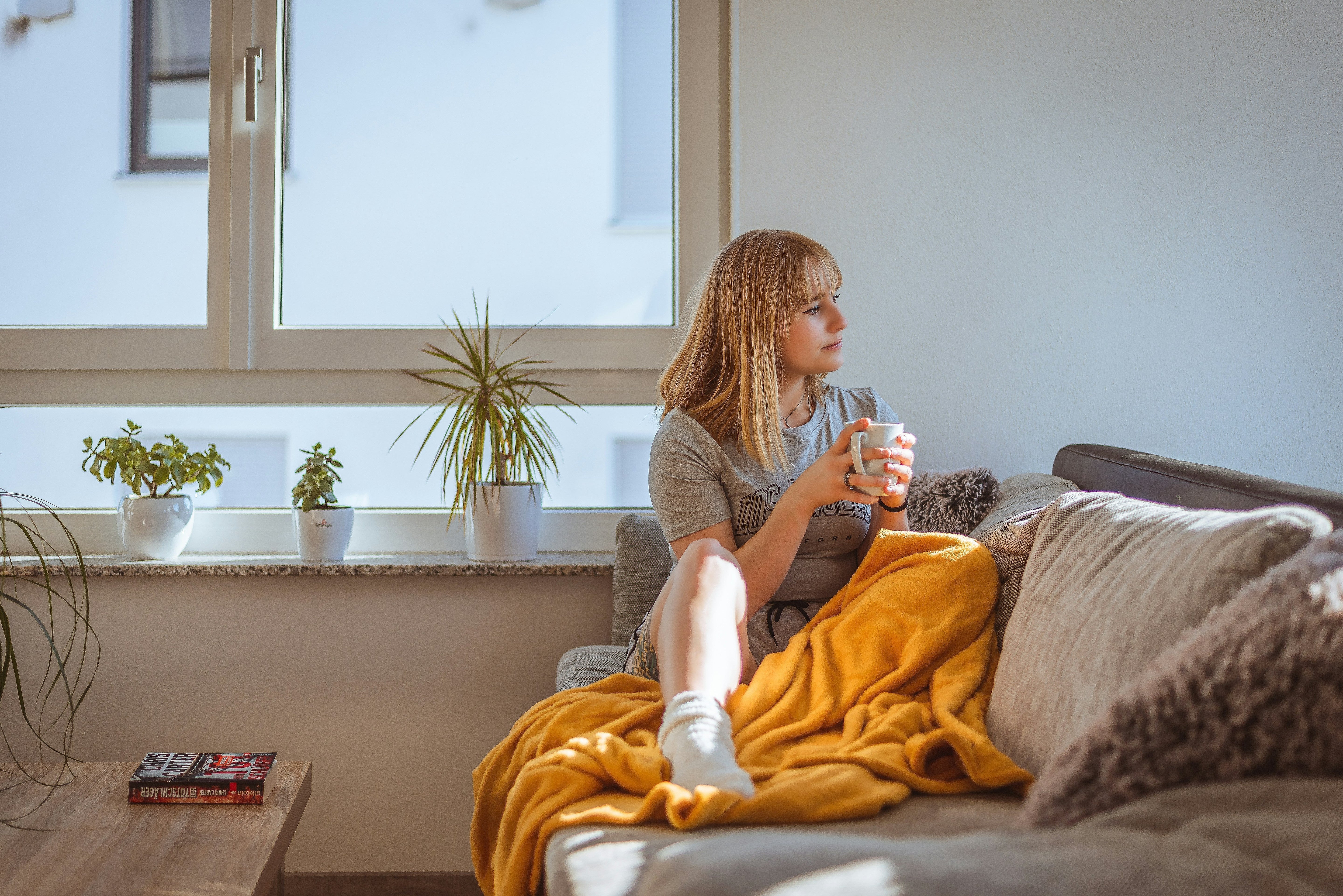 woman sitting on a sofa drinking tea